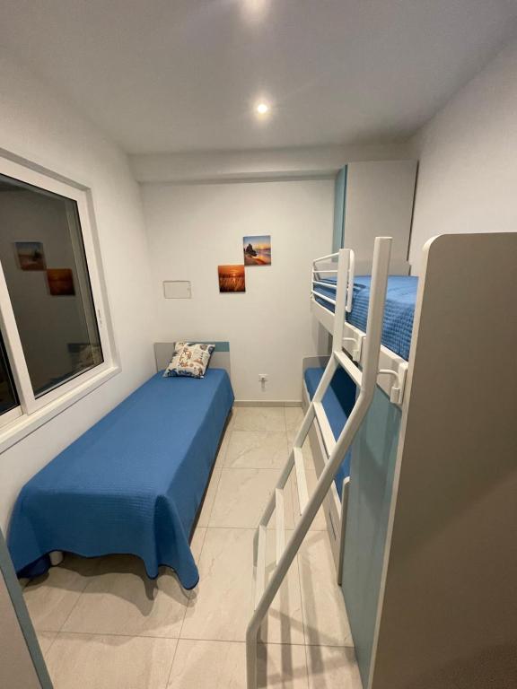 ein kleines Schlafzimmer mit einem Etagenbett und einer Leiter in der Unterkunft Il Veliero dei nonni in Porto Cesareo