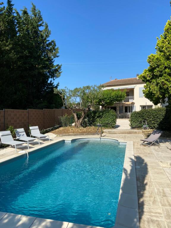 una piscina en un patio con sillas en Gite "Au bout du chemin", en Beaumes-de-Venise
