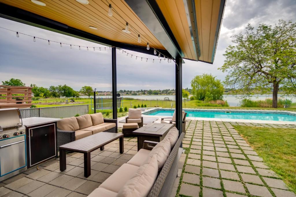 an outdoor patio with a grill and a pool at Lakefront Washington Home with Private Pool and Sauna in Moses Lake