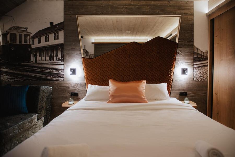 a bedroom with a large bed with a large headboard at Hotel Gleiserei in Oberndorf bei Salzburg