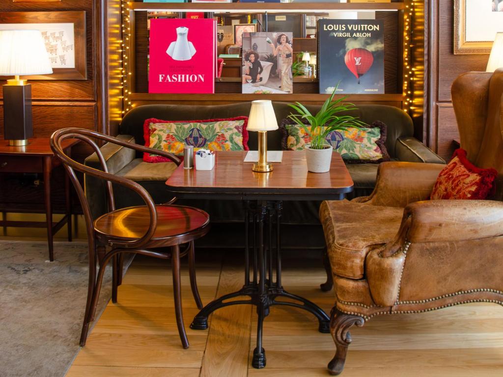 A layered lounge corner combining a sofa, leather armchair and compact café table.