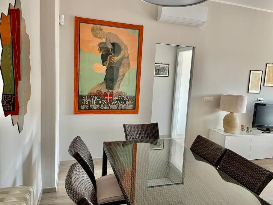 uma sala de estar com uma mesa de vidro e um cartaz de filmes em SUITE DE ROLANDIS CirOO5005OO199 em Asti