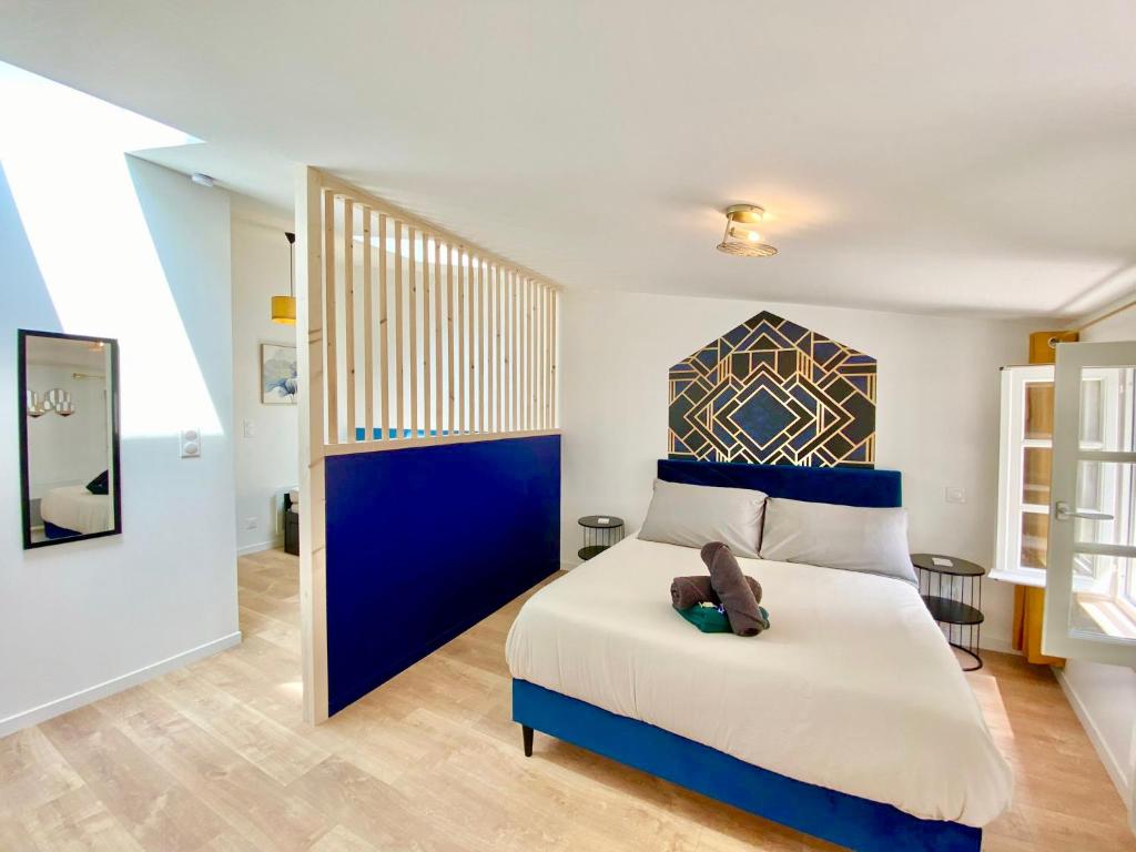 Un dormitorio con una cama con un osito de peluche. en Niort - Hyper-Centre - Appartements en Duplex ou Triplex - Wifi Fibre - NOUVEAU, en Niort