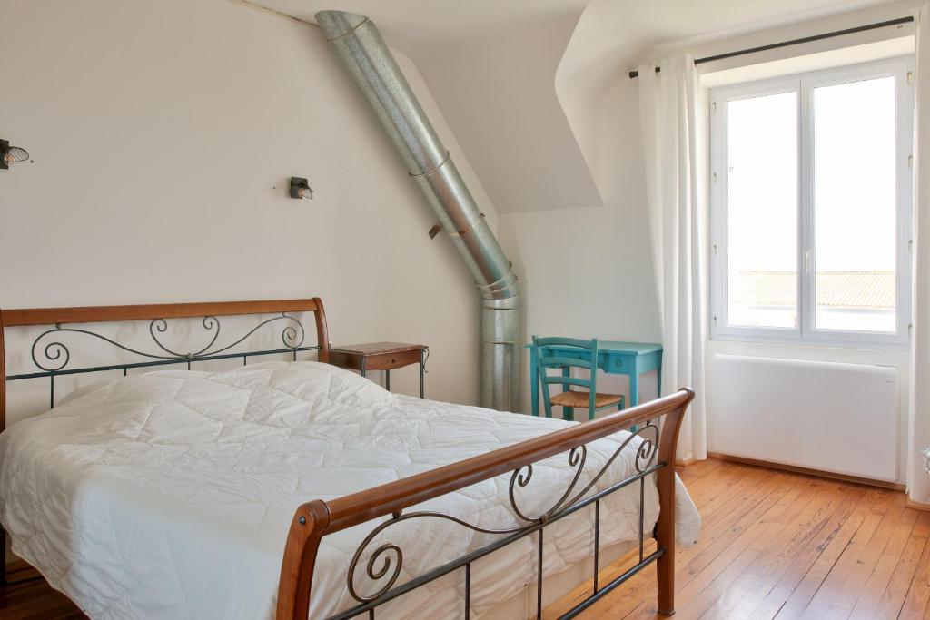 a bedroom with a bed and a staircase with a window at Escapade au calme tout pres de la plage in Penmarch