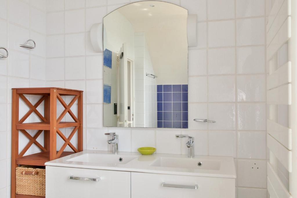 a white bathroom with a sink and a mirror at Escapade au calme tout pres de la plage in Penmarch