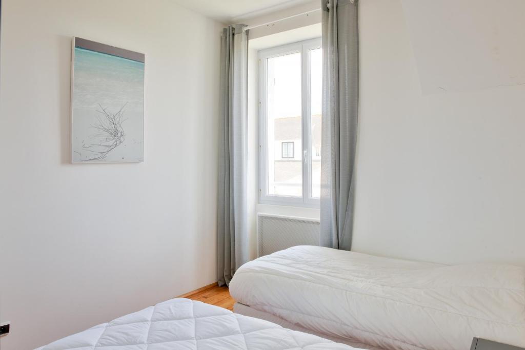 a bedroom with two beds and a window at Escapade au calme tout pres de la plage in Penmarch