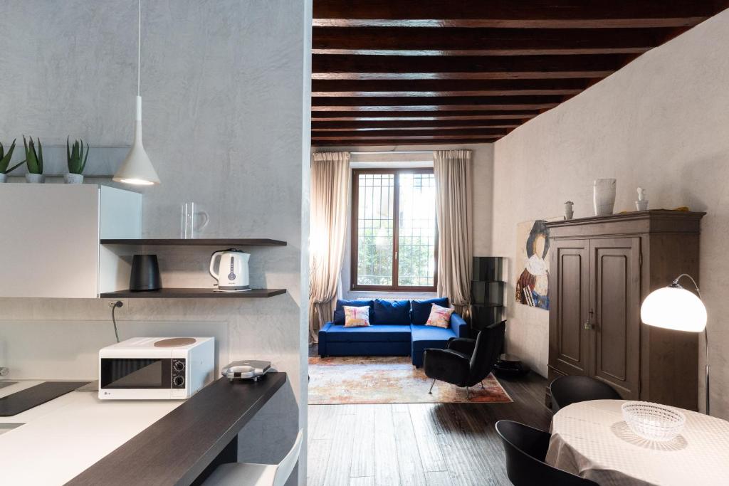 cocina y sala de estar con sofá azul en Rosa Luxury Apartment en Verona