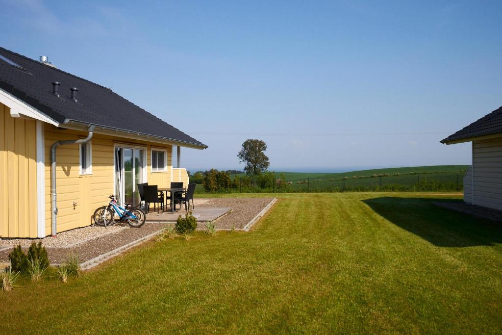 a house with a table and chairs next to a yard at Luxuswellnesshaus Strandburg in Bliesdorf