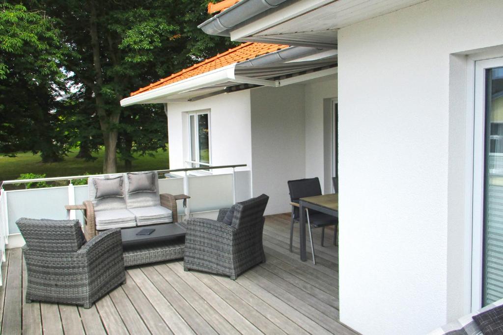 a deck with chairs and a table on a house at Penthouse Parkblick in Grömitz