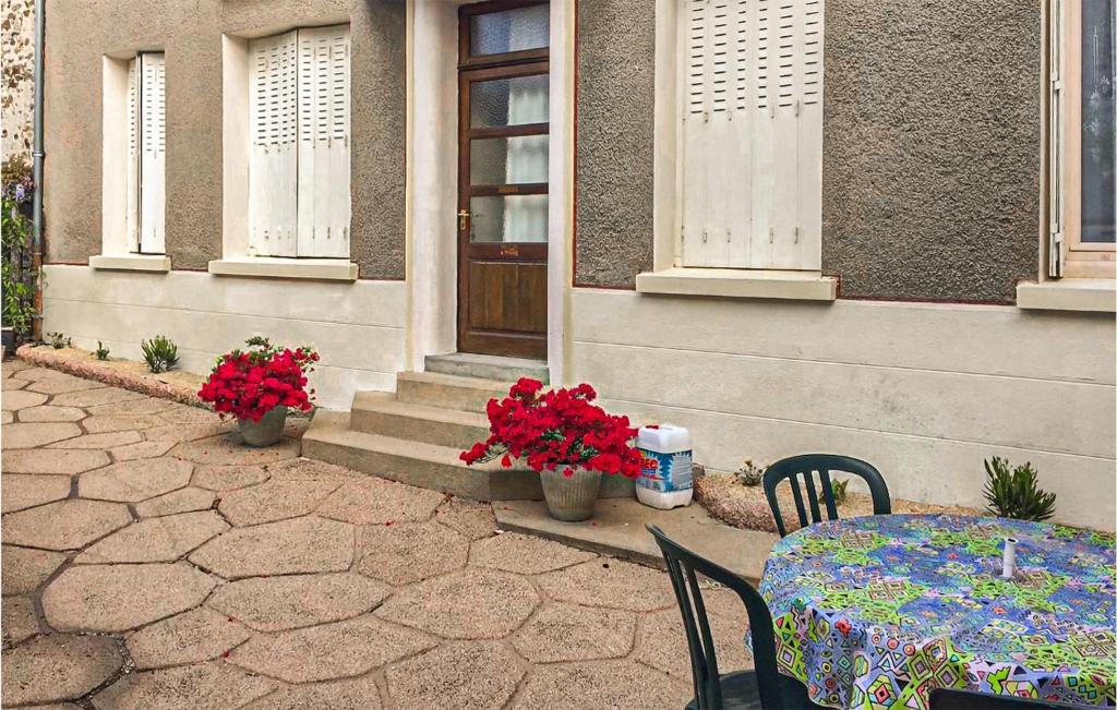einen Tisch und Stühle vor einem Haus mit Blumen in der Unterkunft Lovely Home In Boussac With Kitchen in Boussac