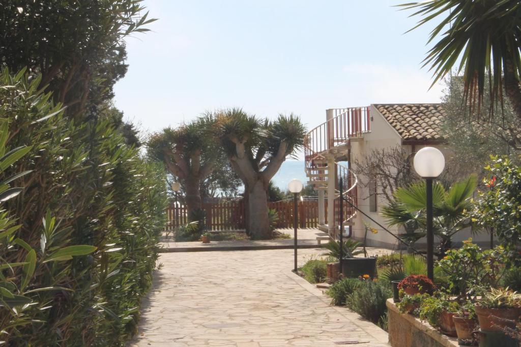 マリーナ・ディ・モーディカにあるCicciuri Relax - fronte mareのヤシの木と家の石畳の私道