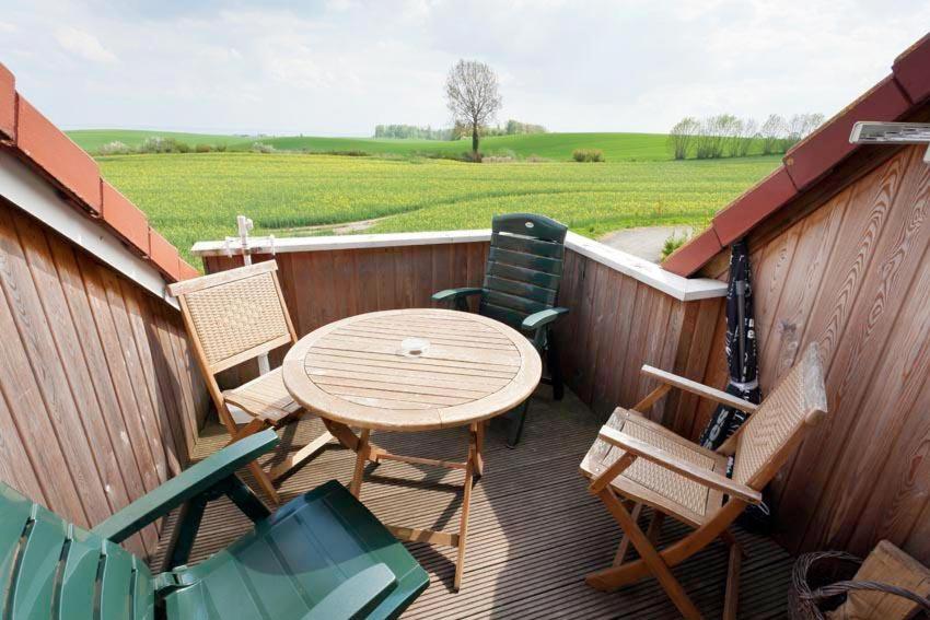 a patio with a table and chairs on a deck at Sperlingslust in Bliesdorf