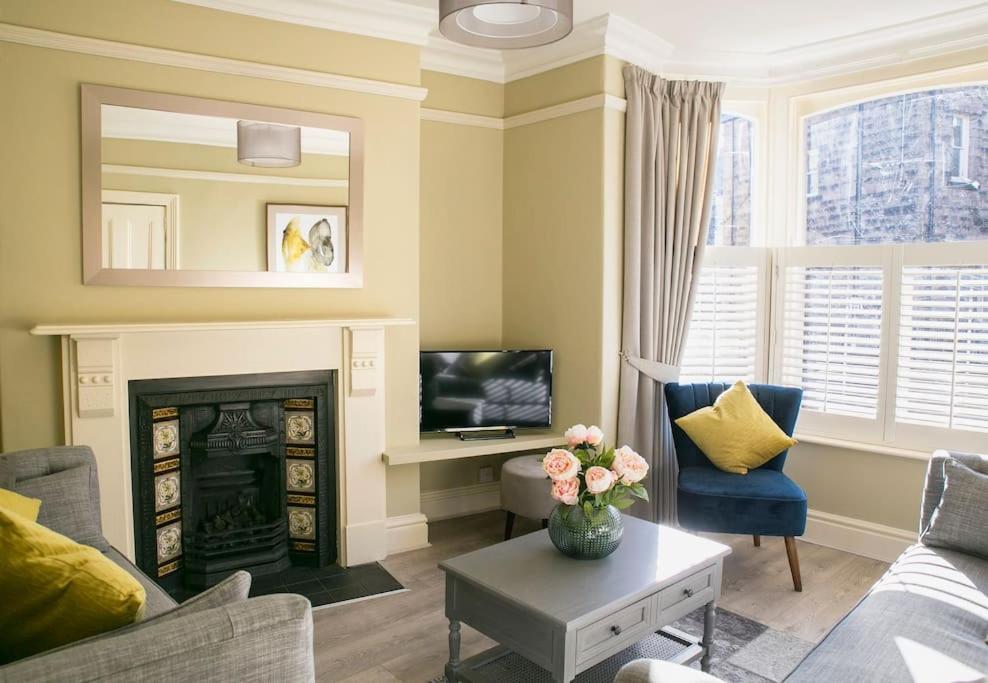 a living room with a fireplace and a tv at Valley Road, Fabulous 4 bedroom house in Harrogate