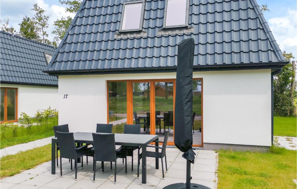 a house with a black roof and a table and chairs at Kavel 15 in Den Oever
