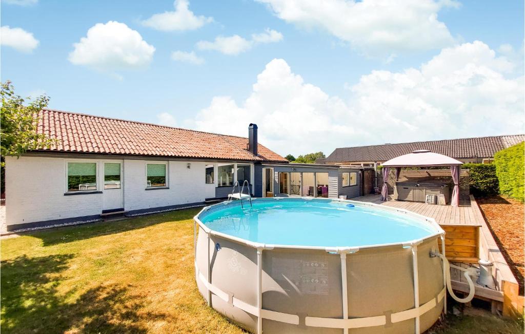 a large swimming pool in a yard next to a house at Cozy Home In Helsingborg With Private Swimming Pool, Can Be Inside Or Outside in Helsingborg