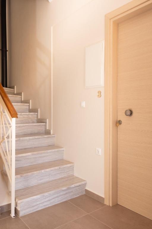 a staircase in a home with a wooden door at Plakoures Home in Kounoupidhianá