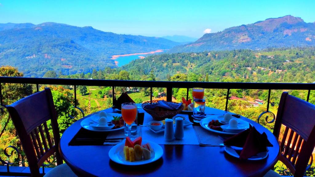 a blue table with food and drinks on a balcony at Floating Mountain Villa in Nuwara Eliya