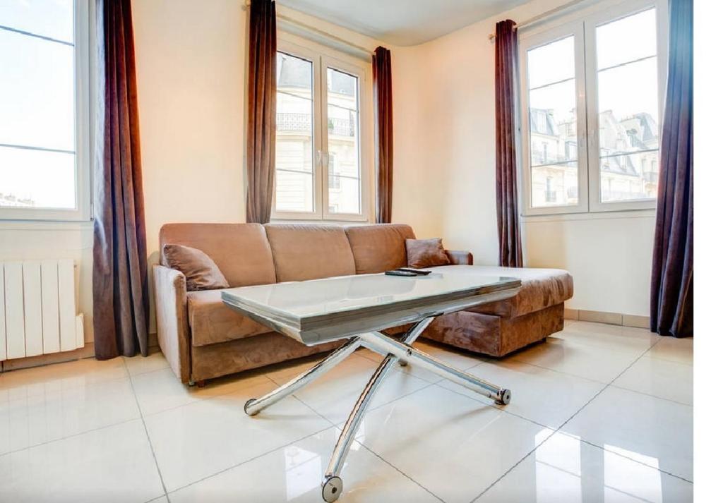 sala de estar con sofá y mesa en Apartment Notre Dame Bright, en París