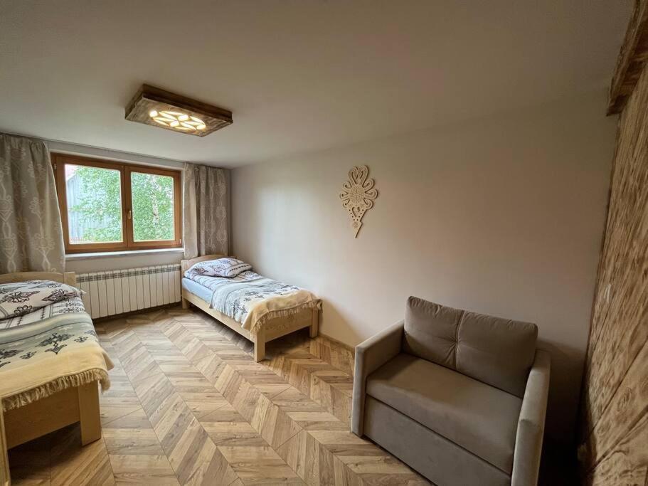 a room with a couch and a bed and a window at Apartament u Bafiów in Chochołów
