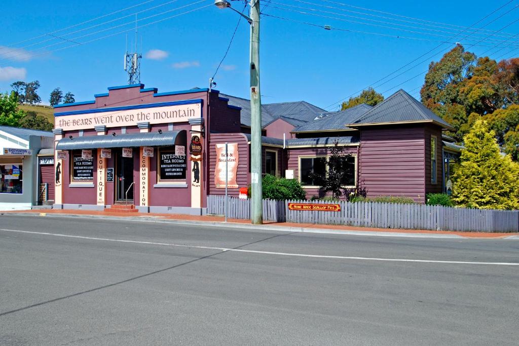 a pink building on a street corner with a street at The Bears Went Over The Mountain in Geeveston