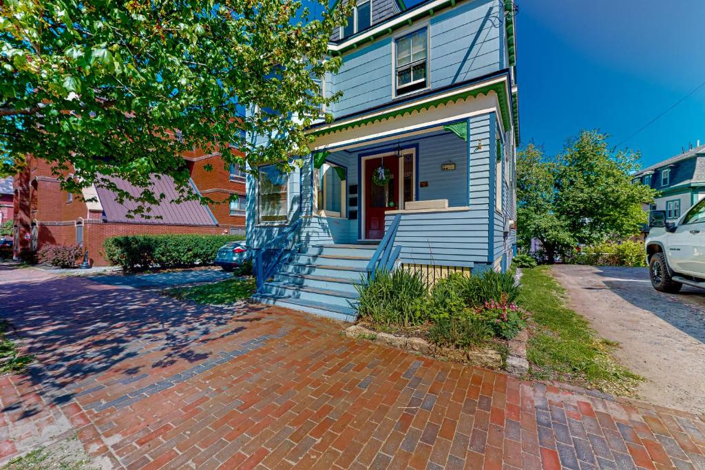 een blauw huis met een rode deur op een stenen oprit bij Cumberland Casa - B in Portland