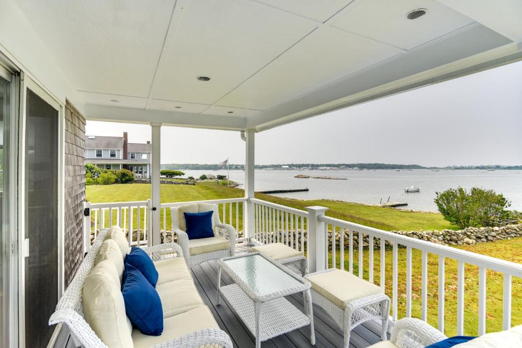 - une terrasse couverte dotée d'un mobilier blanc et offrant une vue sur l'eau dans l'établissement Waterfront Massachusetts Vacation Rental with Deck, à Little Compton
