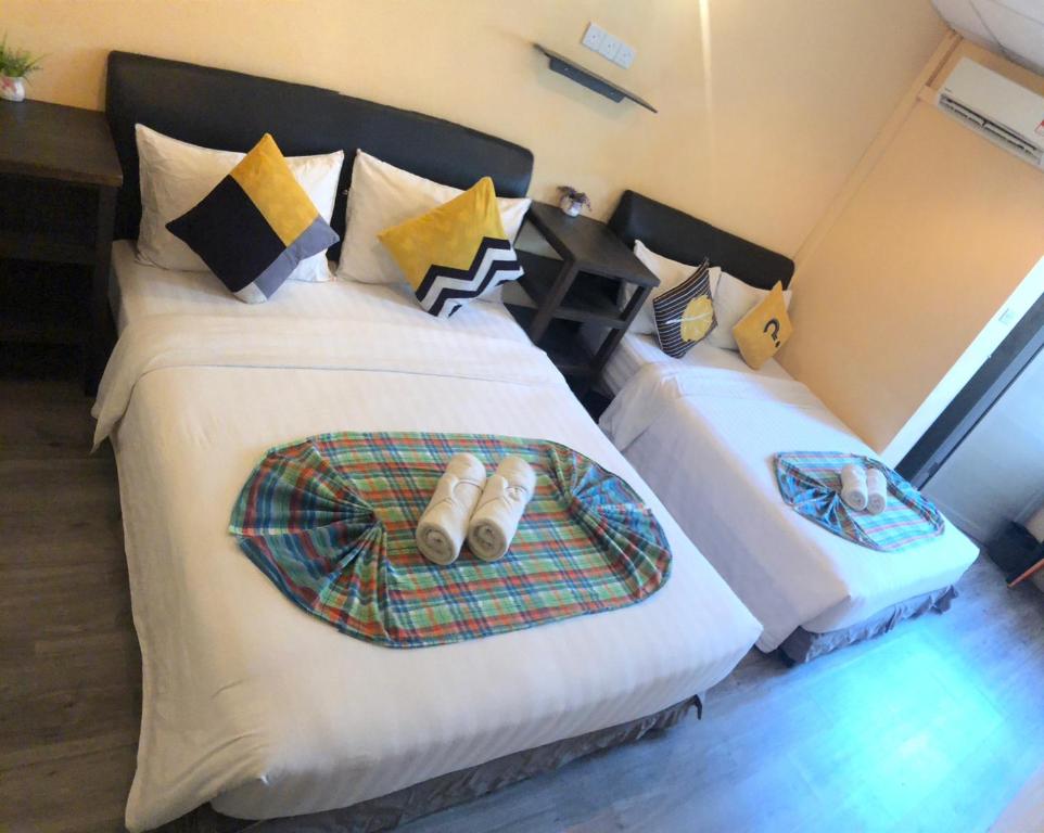 - une chambre avec 2 lits avec des chaussures dans l'établissement Loft Pals Urbanstay Lodge, Kapit, à Kapit