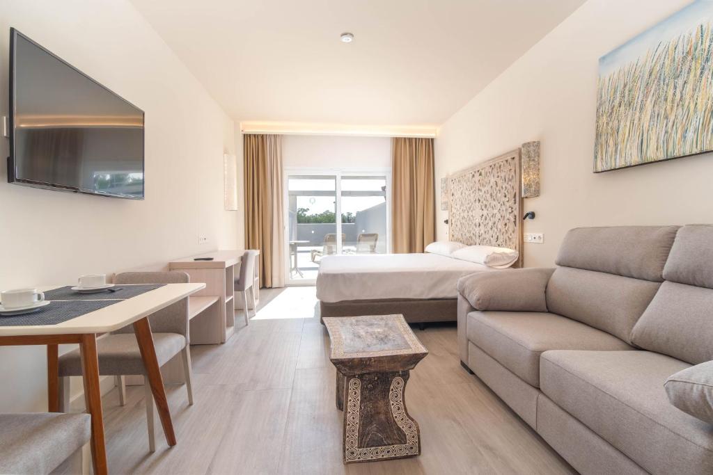 a hotel room with a couch and a bed at Aljarafe Suites by QHotels in Gelves