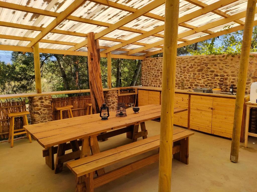 a pavilion with a wooden table and benches in it at Gaia Double or Twin Bell Tent in Swellendam