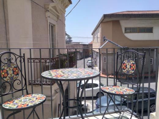 balcón con 2 mesas y sillas en Armony House, en Trecastagni