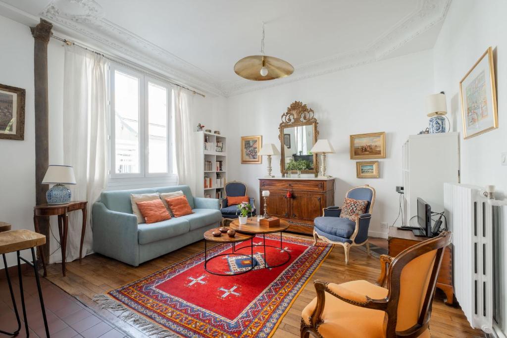 - un salon avec un canapé bleu et un tapis rouge dans l'établissement Veeve - Eminent Grace, à Paris