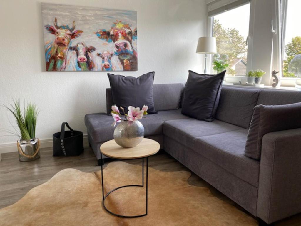 ein Wohnzimmer mit einem Sofa und einem Tisch mit einer Vase darauf in der Unterkunft Anja in Westerland