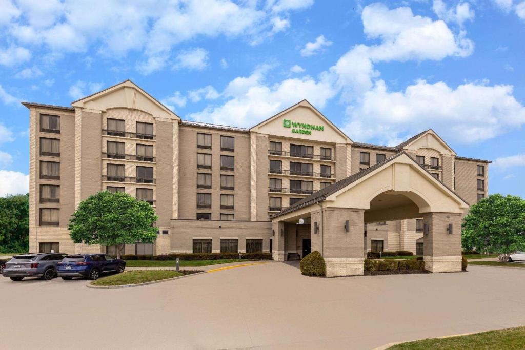 a hotel building with a car parked in a parking lot at Wyndham Garden Kansas City Airport in Kansas City