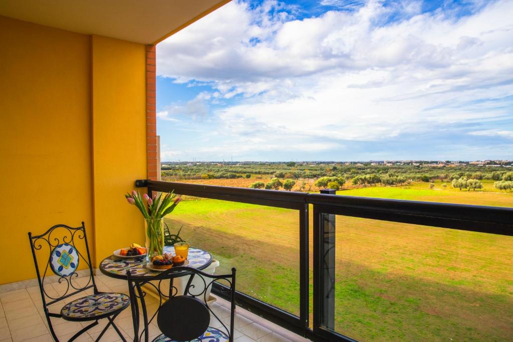 balcón con mesa, sillas y vistas a un campo en Hotel Residence Federiciano en Valenzano