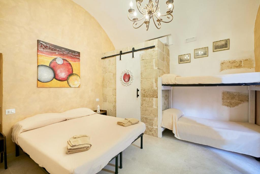 two beds in a room with two bunk beds at Centro Storico Rooms in Gallipoli