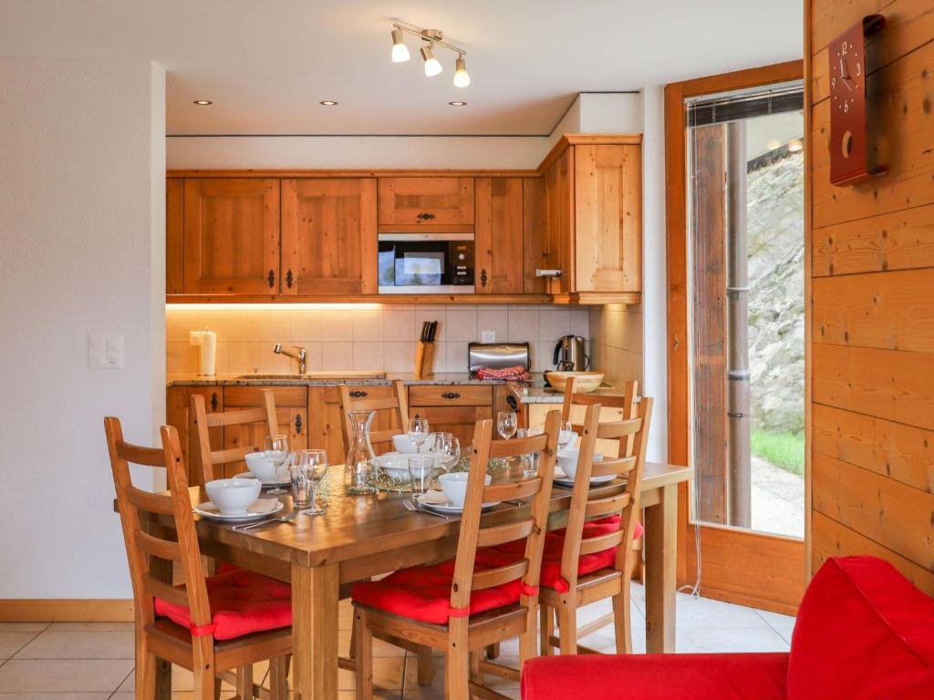 a kitchen with a wooden table with chairs and a dining room at Apartment Les Cimes Blanches 102 A by Interhome in Nendaz
