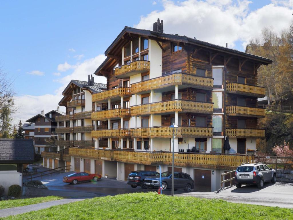 duży budynek z samochodami zaparkowanymi na parkingu w obiekcie Apartment Les Cimes Blanches B 401 by Interhome w mieście Nendaz