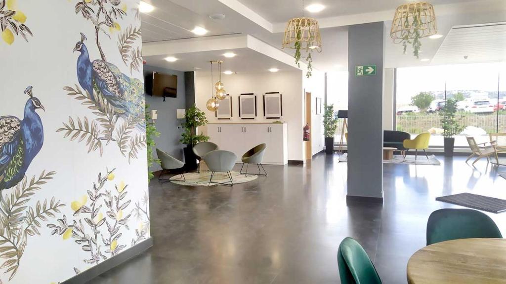 a lobby with chairs and tables in a building at Alda Valladolid Sur in Valladolid