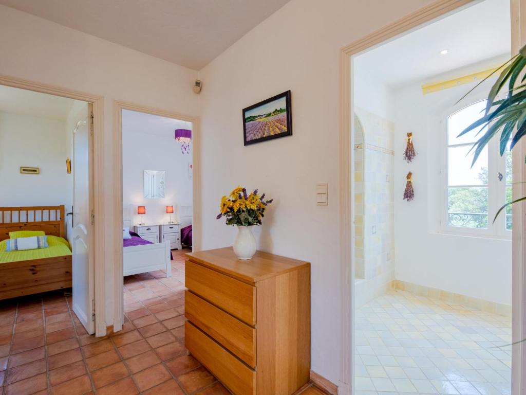a room with a vase of flowers on a dresser at Holiday Home La Bastide Rose by Interhome in Sainte-Maxime