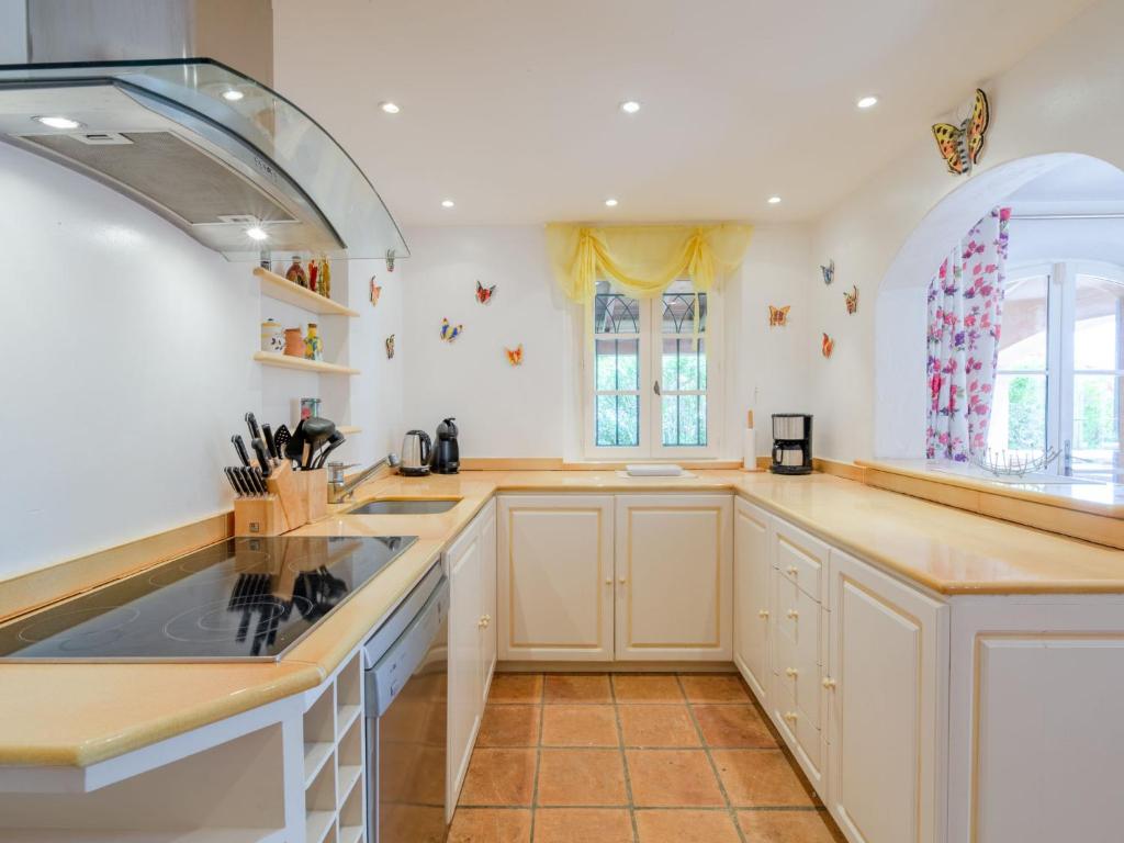 a large kitchen with white cabinets and a sink at Holiday Home La Bastide Rose by Interhome in Sainte-Maxime