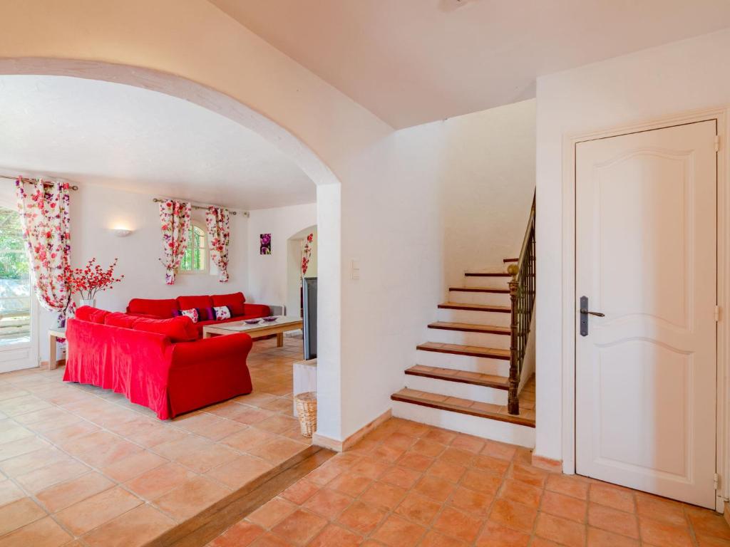 a living room with a red couch and stairs at Holiday Home La Bastide Rose by Interhome in Sainte-Maxime