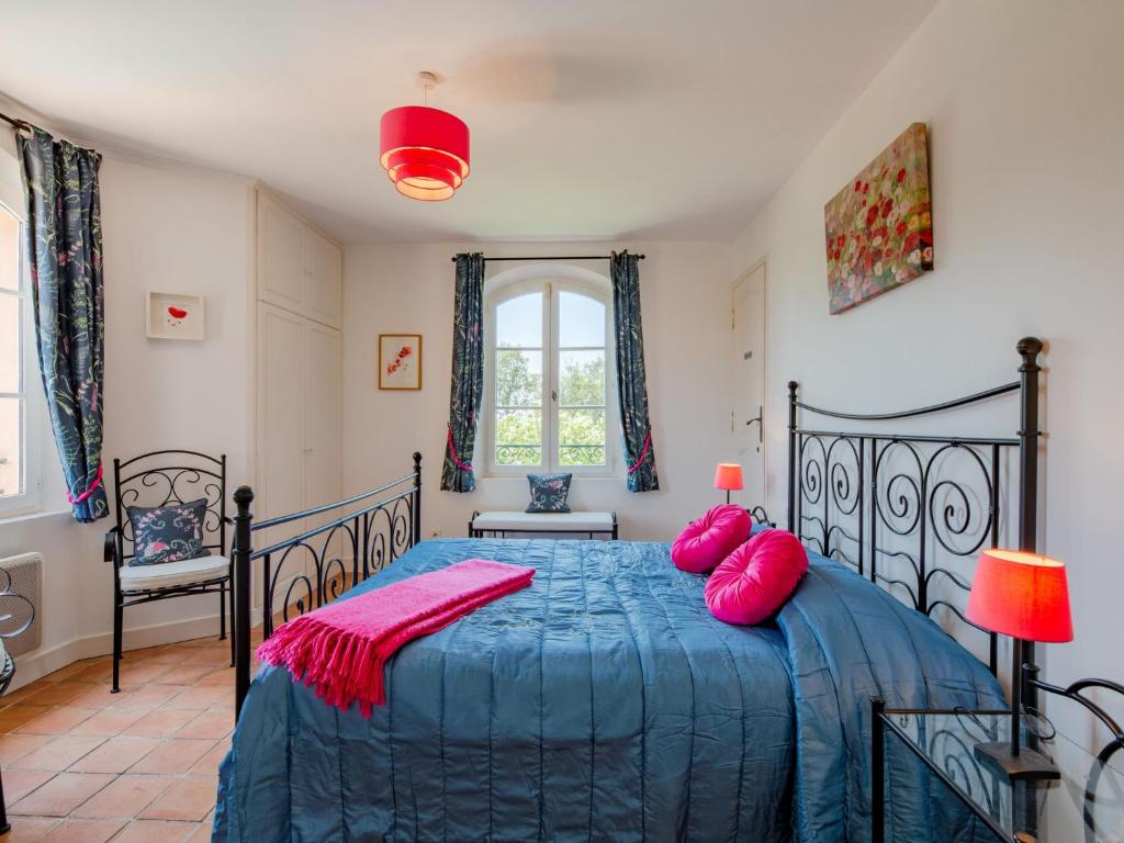 a bedroom with a blue bed with pink pillows at Holiday Home La Bastide Rose by Interhome in Sainte-Maxime