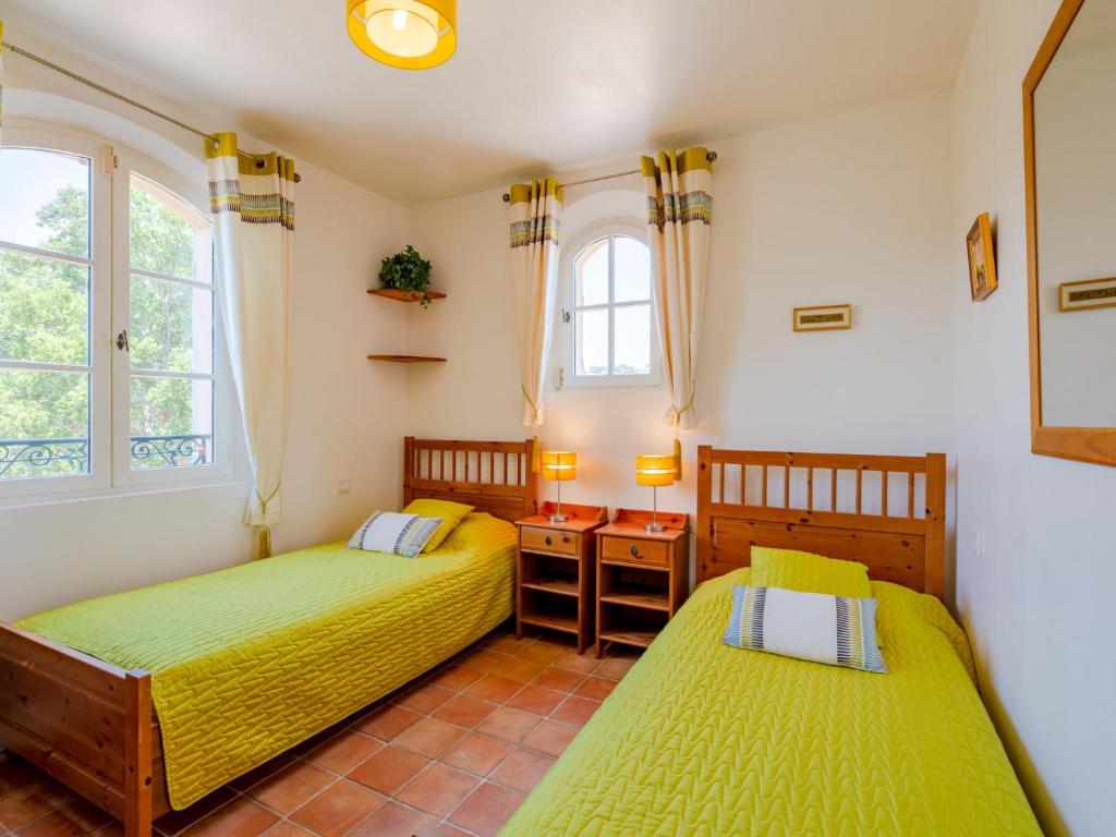 two beds in a room with two windows at Holiday Home La Bastide Rose by Interhome in Sainte-Maxime