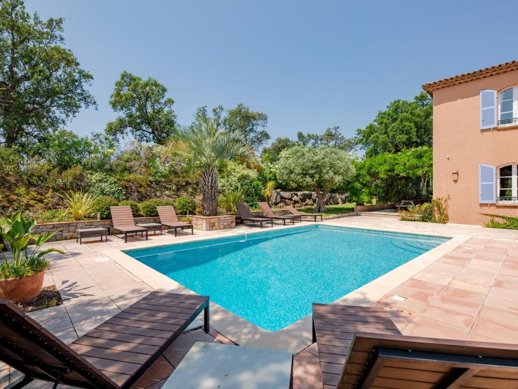 a swimming pool with lounge chairs and a house at Holiday Home La Bastide Rose by Interhome in Sainte-Maxime