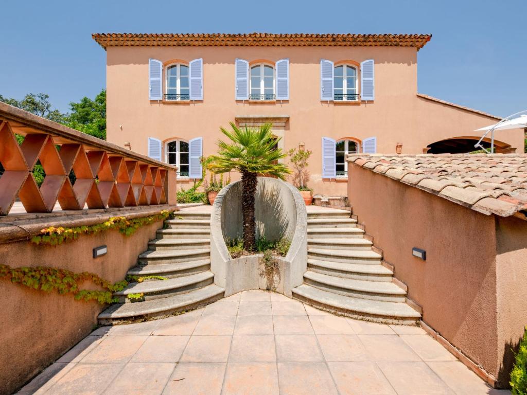 a house with stairs and a palm tree in front of it at Holiday Home La Bastide Rose by Interhome in Sainte-Maxime