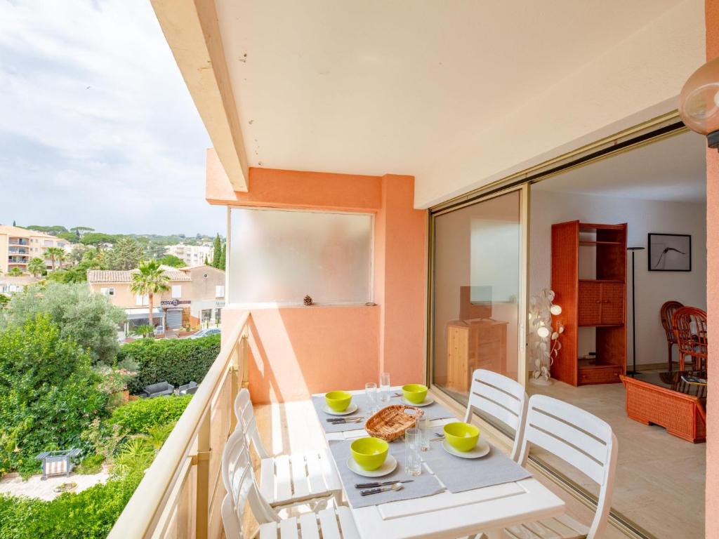 a dining room with a table and chairs on a balcony at Apartment Les Terres Marines by Interhome in Sainte-Maxime