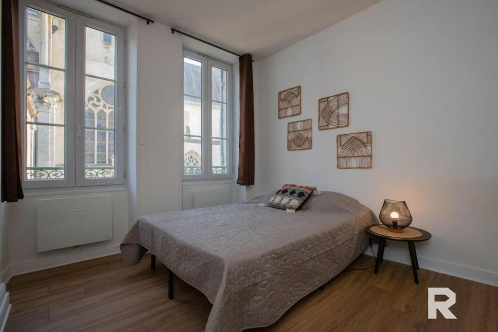 a bedroom with a bed and two windows at Ô Centre- Chaleureux - Fibre - Netflix in Montargis