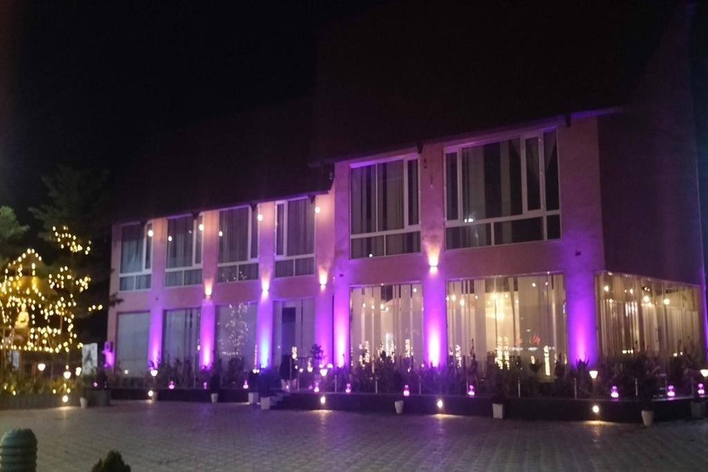 un edificio con luces moradas en él por la noche en Fun N City Water Park , Adventure & Resort , Patna en Nadwān