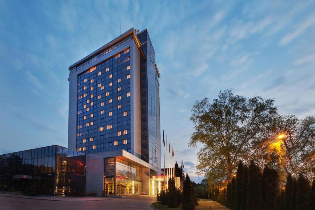 ein hohes Gebäude mit vielen Fenstern in der Unterkunft VILNIUS PARK PLAZA HOTEL, Restaurant & Terrace, Panorama Bar, Conference & Banquet Center in Vilnius