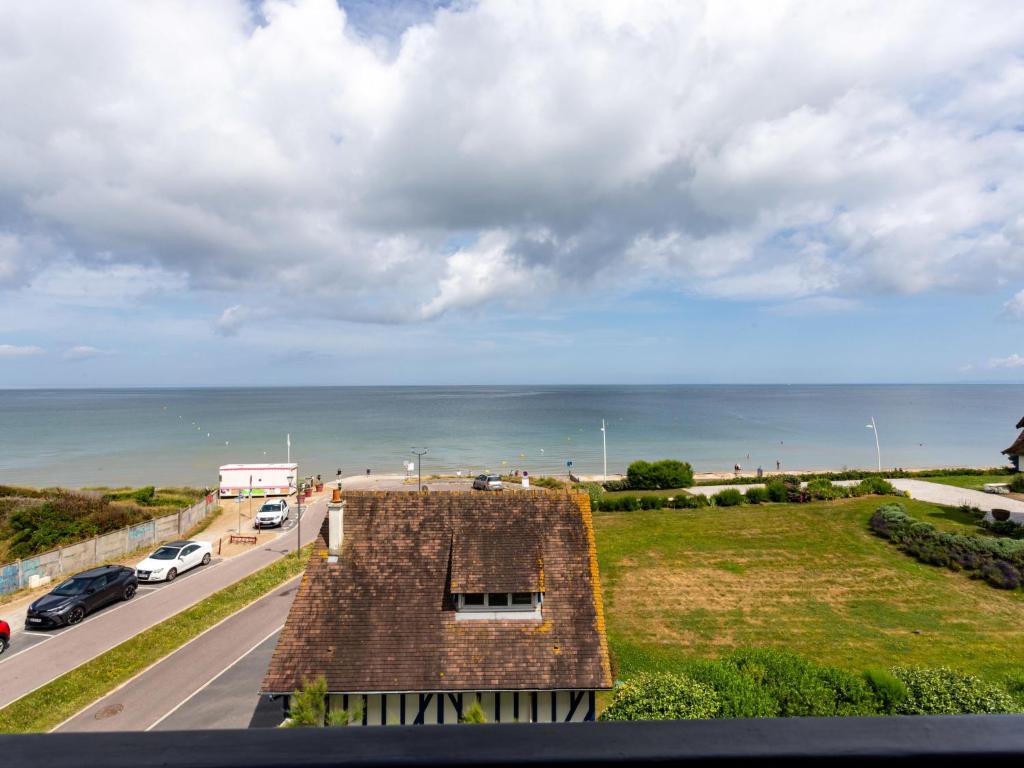 a view of a house with the ocean in the background at Apartment La Bizontine by Interhome in Cabourg